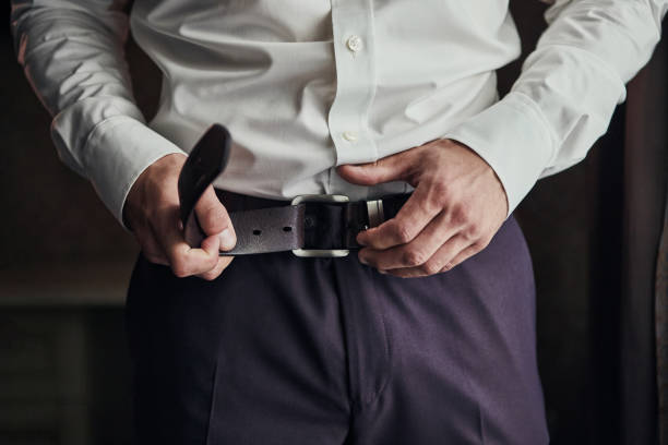 uomo d'affari che indossa un concetto di cintura, moda e abbigliamento, sposo che si prepara la mattina prima della cerimonia - cuff link suit men wedding foto e immagini stock