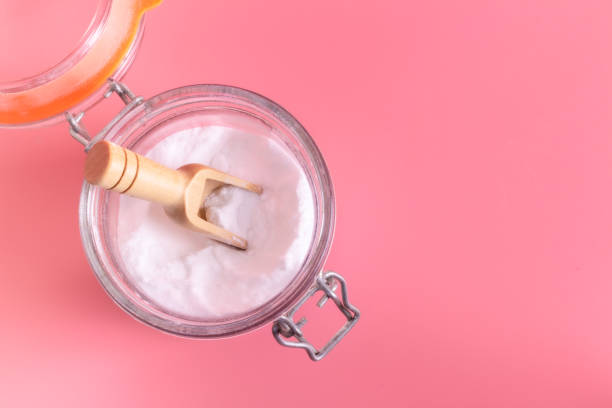 istock Jar and spoonful of baking soda on pink background 1209903967