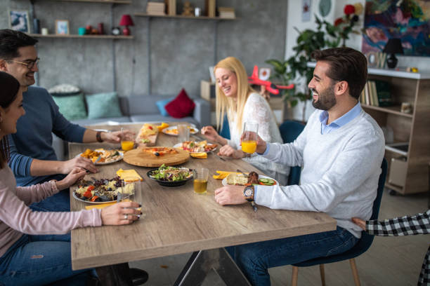 istock Two happy families having fun time during lunch together at home 1209904309