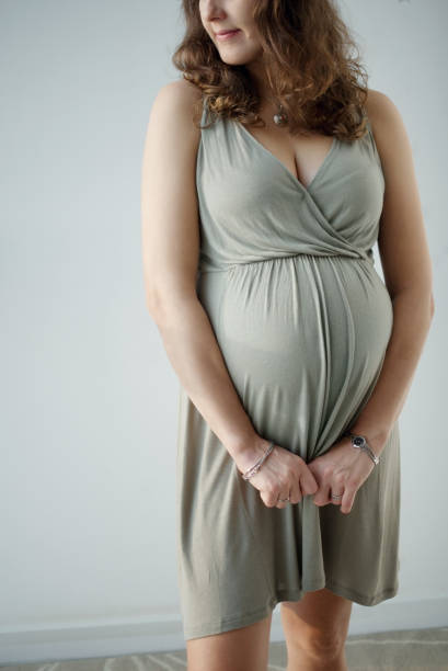 Close up shot of the impersonal pregnant woman with big tummy. Waiting for the baby. Motherhood. Image of pregnant woman touching her big belly. Happy pregnant European woman is waiting for the baby. Pregnancy, motherhood, family, people and expectation concept. olivia mum stock pictures, royalty-free photos & images