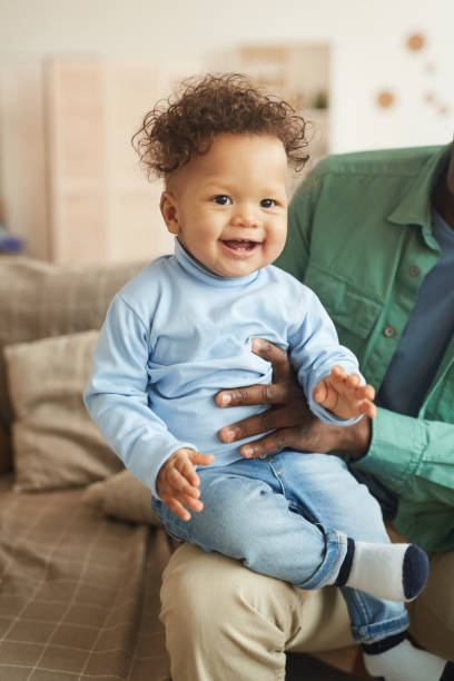 istock Laughing Baby Boy on Fathers Lap 1209906684