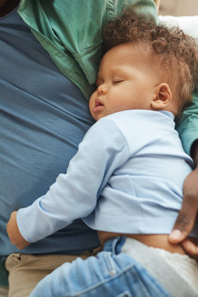 istock Cute Baby Sleeping in Fathers Arms 1209906712