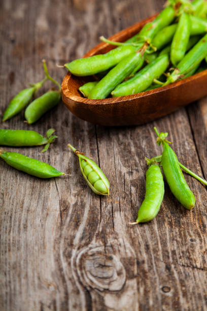 istock Green peas in a wooden bowl. 1209907500