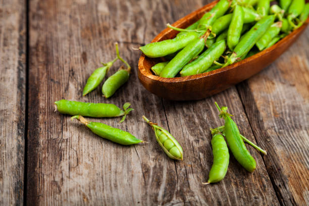 istock Green peas in a wooden bowl. 1209907524