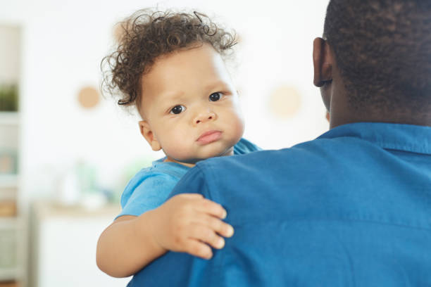 istock Cute Baby Peeking from Fathers Shoulder 1209907554