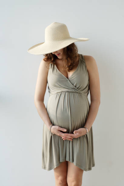 Close up shot of the impersonal pregnant woman in the hat holding her big tummy. Waiting for the baby. Motherhood. Image of happy pregnant woman touching her big belly. European woman with big tummy in the hat. Pregnancy, motherhood, famaly, people and expectation concept. olivia mum stock pictures, royalty-free photos & images