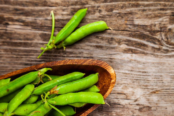 istock Green peas in a wooden bowl. 1209907680
