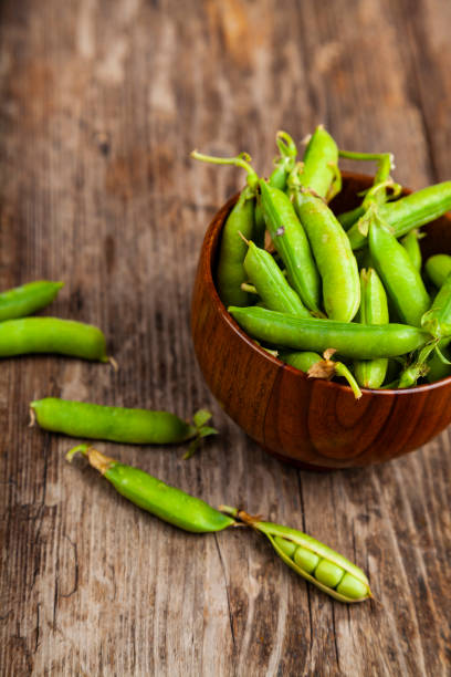 istock Green peas in a wooden bowl. 1209907712