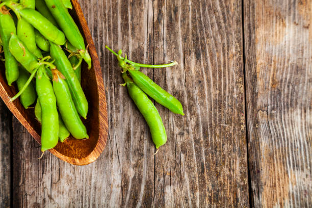 istock Green peas in a wooden bowl. 1209907745