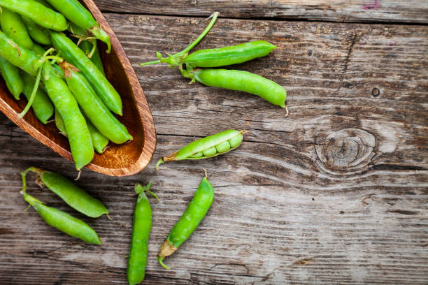 istock Green peas in a wooden bowl. 1209907822