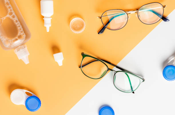 Optical glasses, contact lenses and eye drops Optical glasses, contact lenses and eye drops on a yellow and white background, top view, flat lay. lens optical instrument stock pictures, royalty-free photos & images