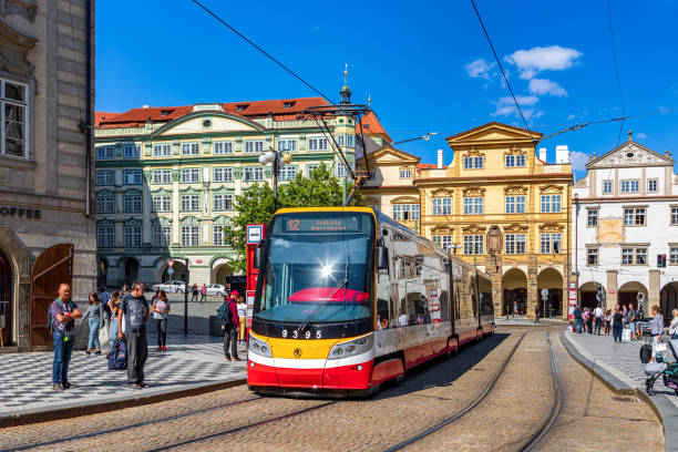 PRAGUE, CZECH REPUBLIC - SEPTEMBER 03, 2019: Modern tram on cobblestone street among colorful houses in Old Town  of Prague - famous and popular travel destination.
