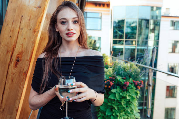 Beautiful young woman having wine on terrace