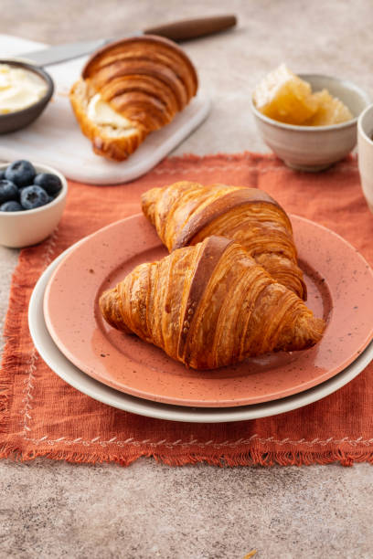 istock Fresh croissants with blueberries and honey, gray background. 1209909880