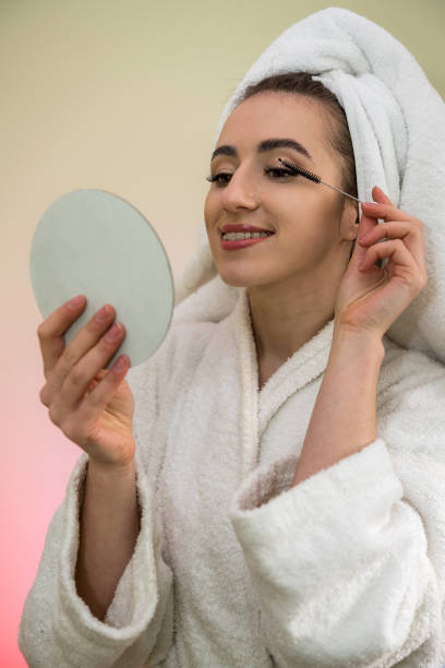 istock Beautiful girl paints eyelashes morning before work isolated on green 1209910156