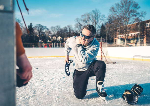 vater und sohn spielen hockey im freien - ice skating ice hockey child family stock-fotos und bilder