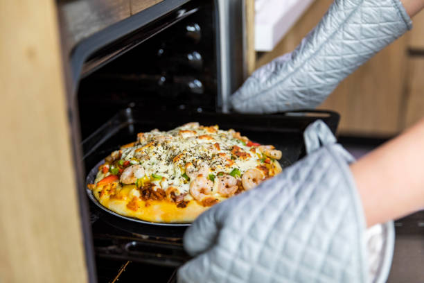 Woman baking pizza in the kitchen at home.