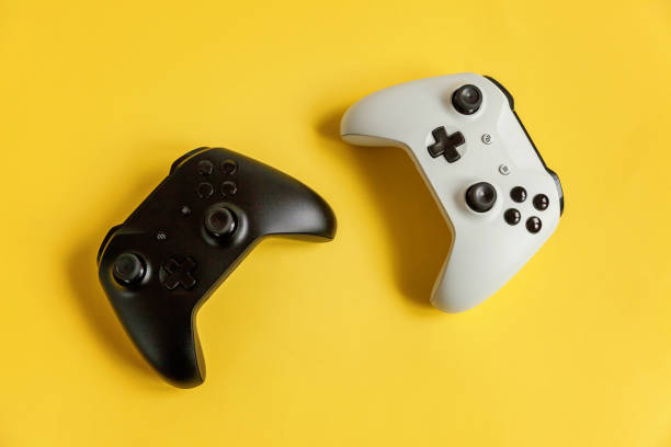 console de jeu de jeu de manette de jeu de manette de joystick blanche et noire sur le fond de pin-up moderne à la mode coloré jaune. concept de confrontation de contrôle de jeu vidéo de jeu vidéo de concurrence d’ordinateur. symbole de cyberespace - video game joystick leisure games control photos et images de collection