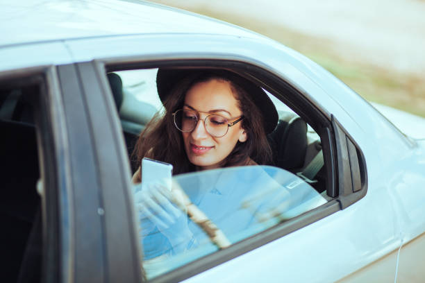 женщина, используя мобильный телефон в автомобиле - car phone стоковые фото и изображения