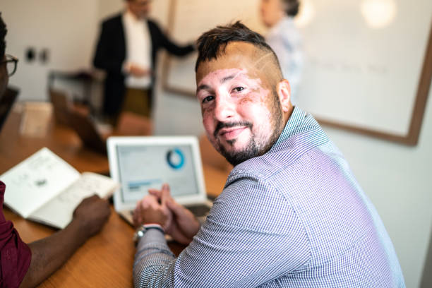 verticale de l’homme d’affaires avec le vitiligo à la salle de réunion - boardroom chairs photos et images de collection