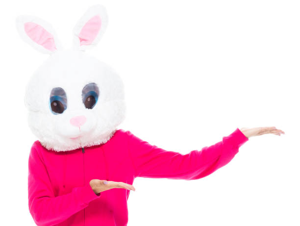Portrait of aged 20-29 years old who is beautiful with long hair generation z female presenter standing in front of white background wearing costume who is bizarre who is showing with hand presenting and wearing wearing a rabbit mask mask