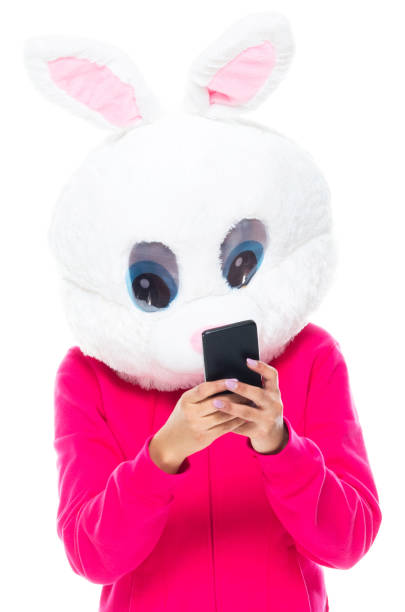 istock Generation z female standing in front of white background wearing costume and using mobile phone 1209918082
