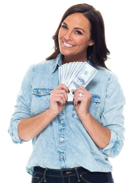 mujer caucásica de pie frente al fondo blanco usando camisa y manteniendo la moneda - laughing women us paper currency isolated fotografías e imágenes de stock
