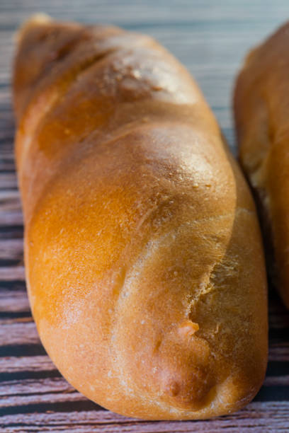 istock Whole grain bread put on kitchen wood plate with a chef holding gold knife for cut. Fresh bread on table close-up. Fresh bread on the kitchen table The healthy eating and traditional bakery concept 1209918762