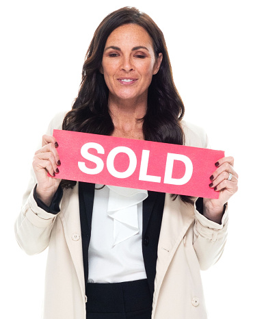 Front view of aged 40-44 years old who is beautiful with brown hair caucasian young women business person standing in front of white background wearing businesswear who is happy and holding sign
