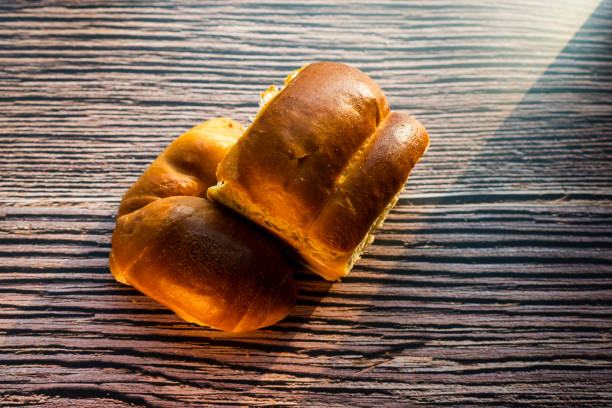 istock Whole grain bread put on kitchen wood plate with a chef holding gold knife for cut. Fresh bread on table close-up. Fresh bread on the kitchen table The healthy eating and traditional bakery concept 1209920100