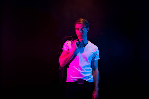 istock Caucasian young male in front of multi-colored background wearing leather jacket 1209922079