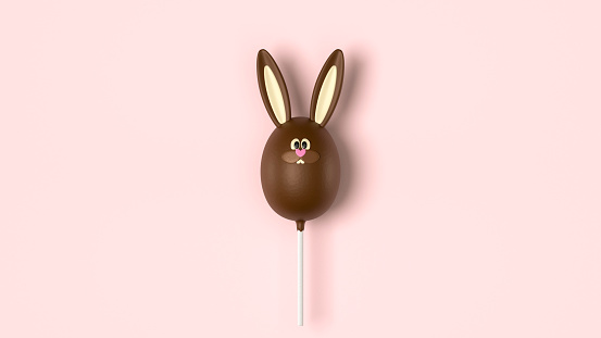 Traditional funny rabbit candy in shape of egg. Chocolate Easter bunny, stick candy on pink background, top view. Sweet cute dessert, Easter holiday hunt symbol, milk chocolate rabbit, space for text.