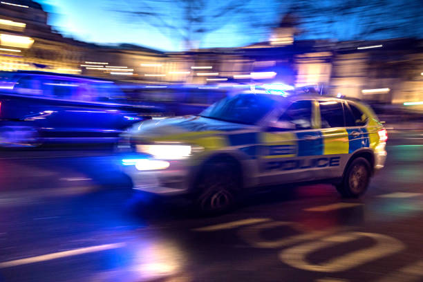 At night a car of the police passing fast in Trafalgar Square.
