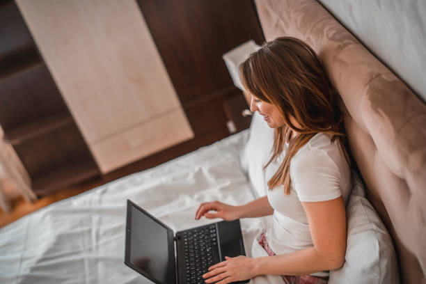 istock Woman with laptop on the bed 1209927428