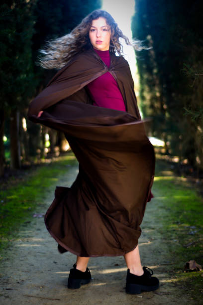 istock Beautiful woman with cape on a path in the woods 1209929668