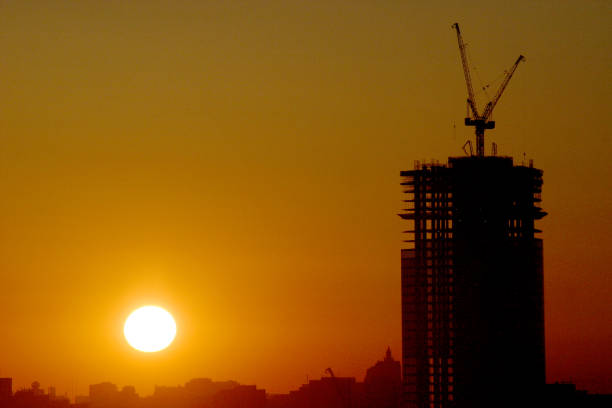 istock Silhouette of a building under construction against the rising sun 1209930278