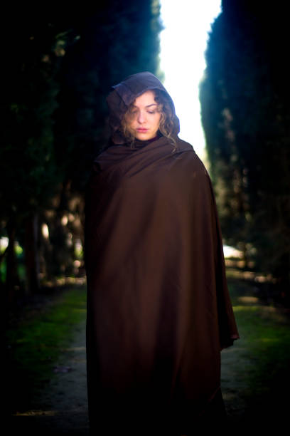 istock Beautiful woman with cape on a path in the woods 1209930327
