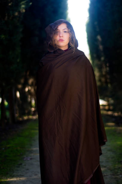istock Beautiful woman with cape on a path in the woods 1209930361