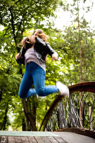 istock Young woman jumping into the air 1209931712