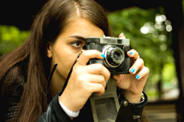 istock Young woman holding old camera 1209931856