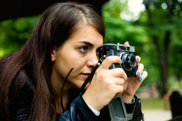 istock Young woman holding old camera 1209931972