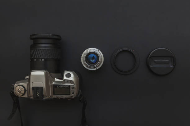 istock Photographer workplace with dslr camera system and lens on dark black table background. Hobby travel photography concept. Flat lay top view copy space 1209934416
