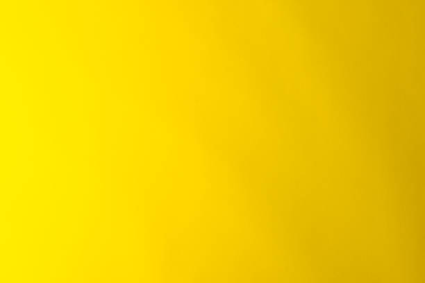 istock Yellow background made of real colored paper, illuminated by a soft light from the left. 1209940691