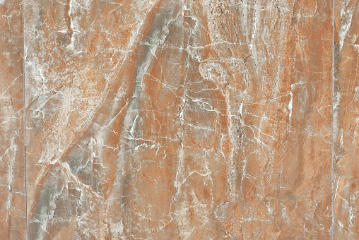 Texture of yellow and orange marble. Stone tile with natural pattern. Marble pavement closeup.