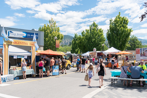 Penticton, British Columbia/Canada - June 15, 2019:  food trucks and shoppers fill the street at the Penticton Community Market, the largest outdoor market in the South Okanagan. This downtown market runs every Saturday from May to September and is a popular event for tourists and locals