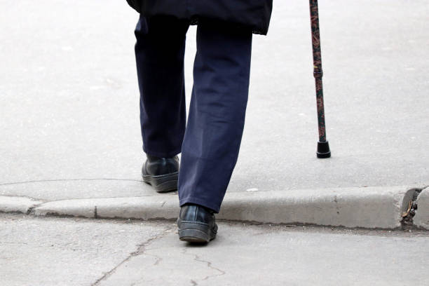 istock Man walking with a cane down the street 1209943922