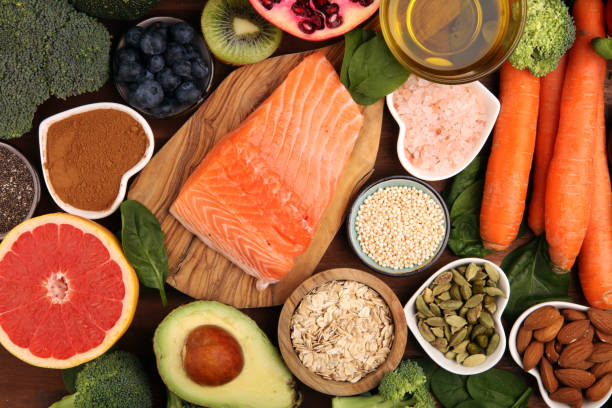 istock Healthy food clean eating selection: fish, fruit, vegetable, cereal, leaf vegetable on rustic background 1209944806