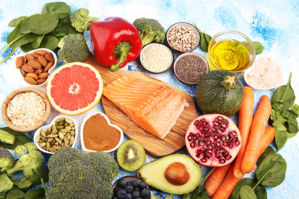 istock Healthy food clean eating selection: fish, fruit, vegetable, cereal, leaf vegetable on rustic background 1209945277