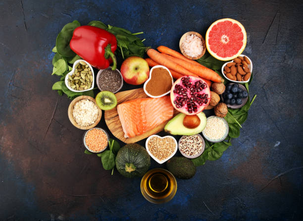 istock Healthy food clean eating selection: fish, fruit, vegetable, cereal, leaf vegetable on rustic background 1209945474