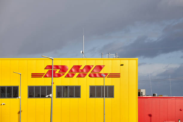 point de service à la clientèle de parcel de dhl avec le ciel orageux à l’arrière-plan. - brand name yellow red business photos et images de collection